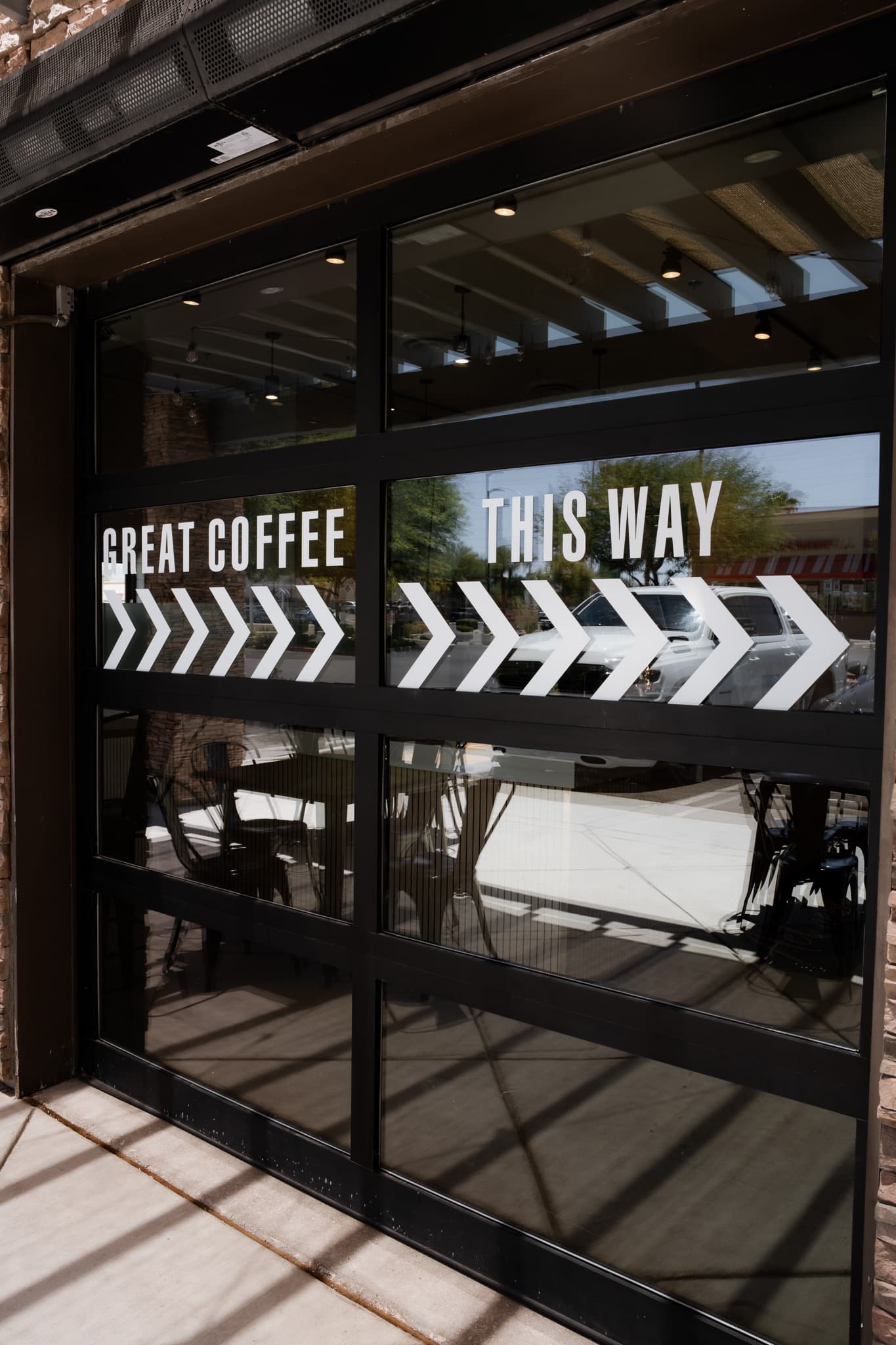 Glass garage door with GREAT COFFEE THIS WAY lettering